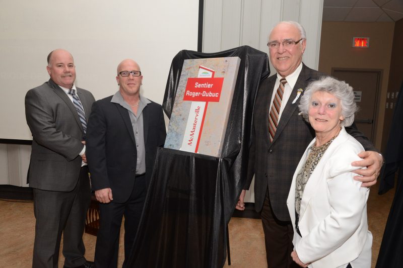 Le maire de McMasterville Gilles Plante présente la plaque honorifique aux membres de la famille Dubuc.
