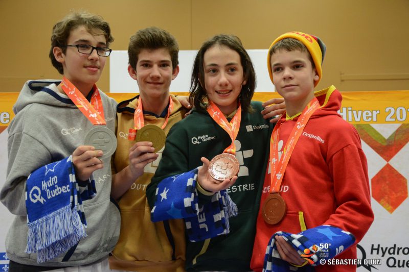 Mathieu Bissonnette (à droite en rouge) tenant sa médaille de bronze obtenue aux Jeux du Québec en combat individuel.