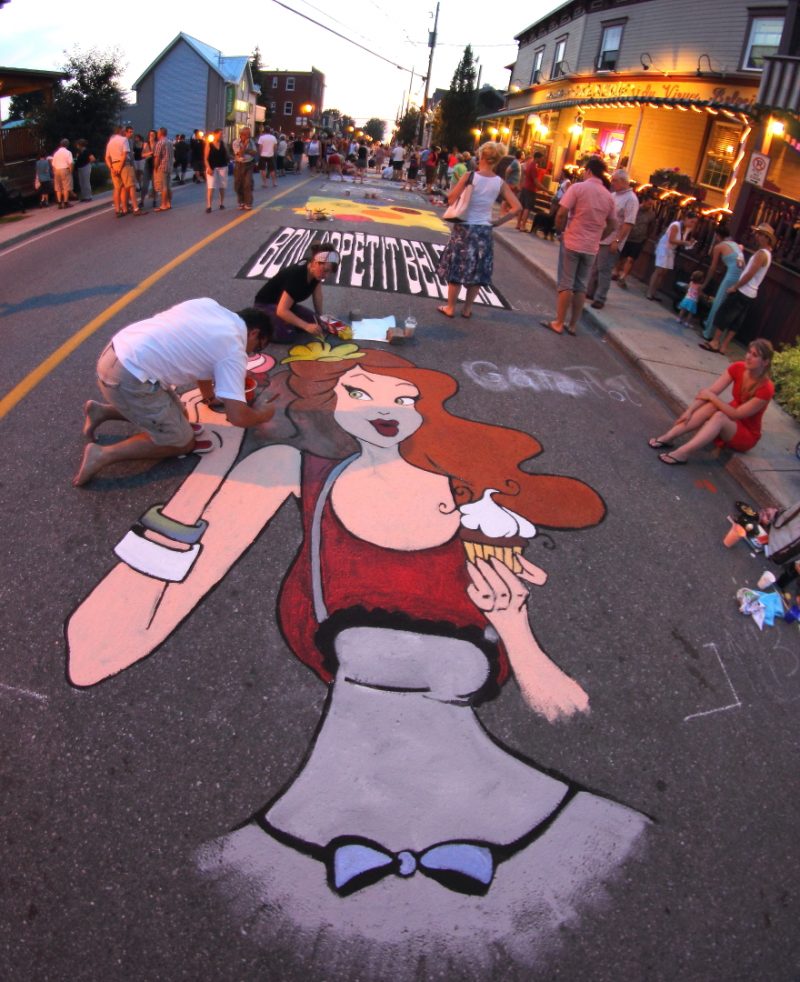 Un artiste peint en direct dans les rues du Vieux-Beloeil à l'occasion de l'événement L'art sur Goudron.