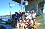 Des scouts descendent la rivière en radeau de fortune