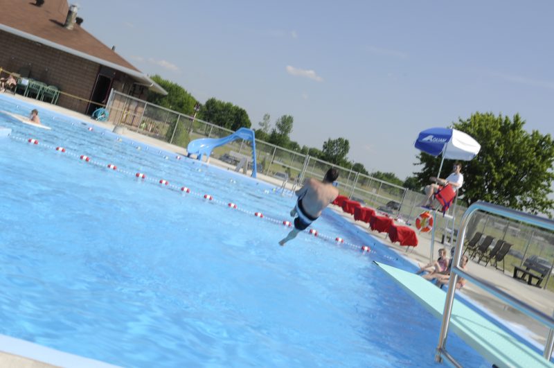 Un enfant saute à l'eau dans une pisicne municipale.