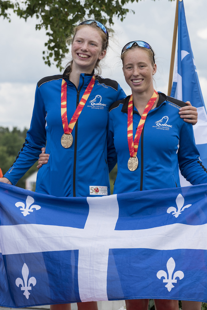 Marilou Duvernay-Tardif (gauche) brandissant fièrement le drapeau du Québec avec la médaille d’or au cou. Photo : Jeux du Canada 