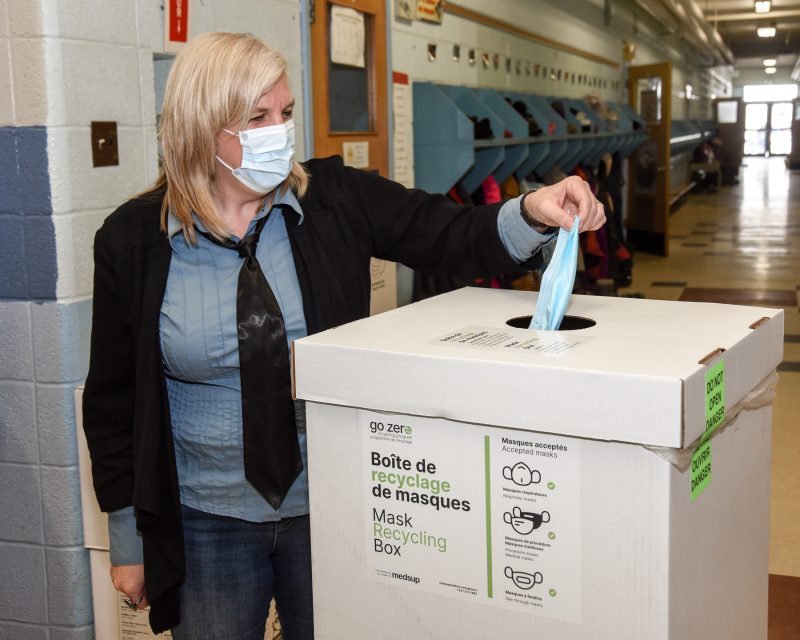 Sophie Lapointe, directrice de l’école Mountainview, dépose un masque de procédure au recyclage.Photo François Larivière | L’Œil Régional ©