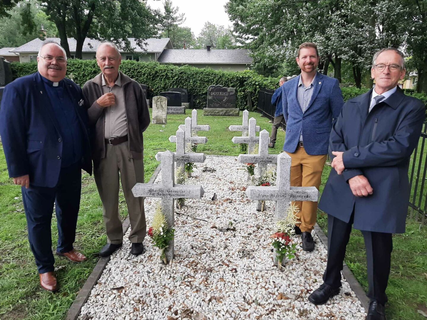 Le curé Pierre Cordeau, le Dr Patrick Binay, le député de Pierre-Boucher – Les Patriotes – Verchères, Xavier Barsalou-Duval, et le président de la Société d’histoire des Riches-Lieux, Guy Archambault, posent près des huit croix en granite érigées en hommage aux huit patriotes de Saint-Denis-sur-Richelieu morts au combat en novembre 1837. Photo Vincent Guilbault | L’Œil Régional ©