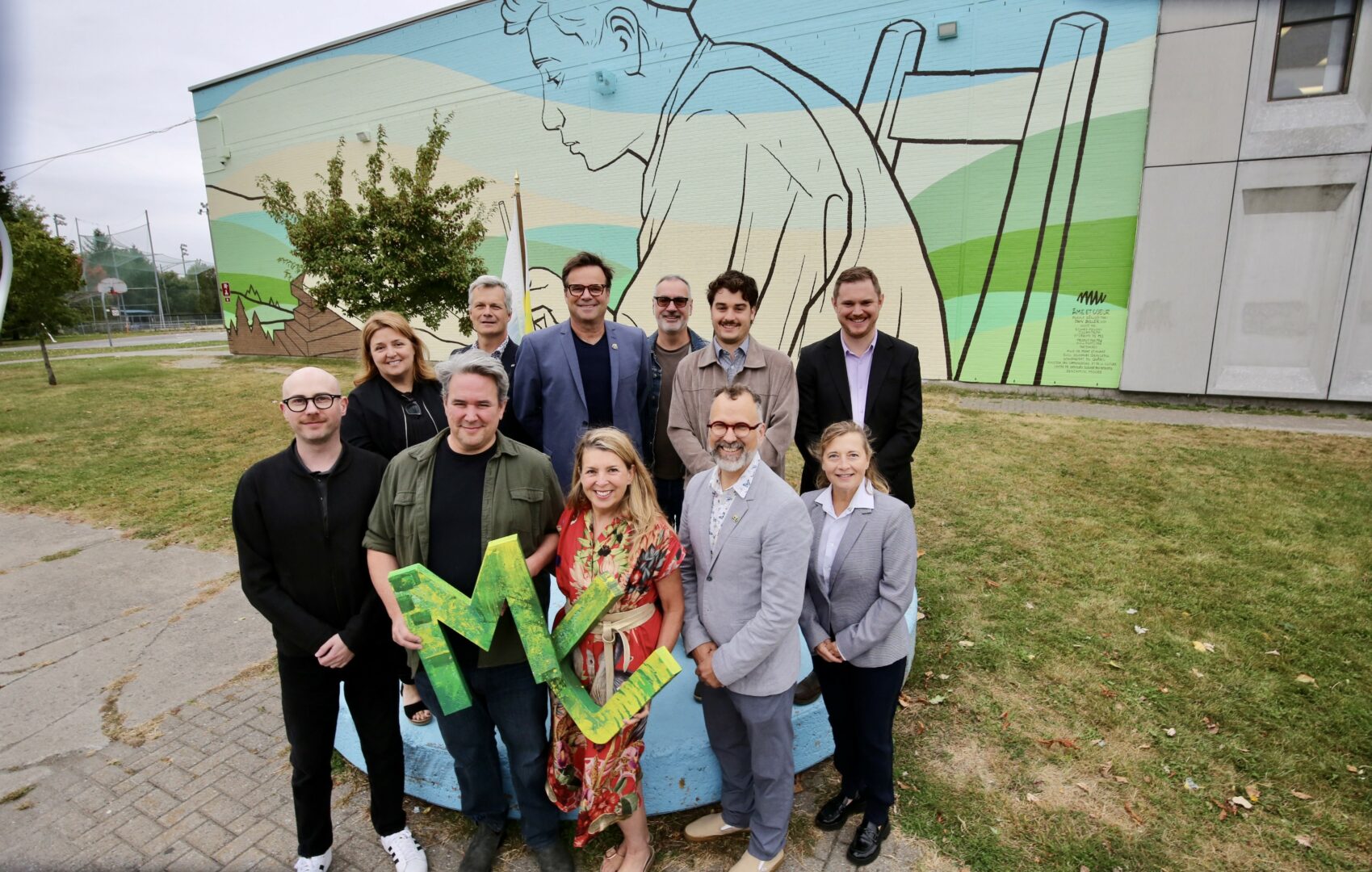 Plusieurs personnes se sont déplacées pour l’inauguration de l’immense fresque à l’école secondaire Ozias-Leduc, dont Edward Maloney et Dan Buller, artistes, Élizabeth-Anne Doyle, de l’organisme MU, Marc-André Guertin, maire de Mont-Saint-Hilaire, et Lucie Blanchet, de Mont-Saint-Hilaire (à l’avant). À l’arrière : Nathalie Huchette, directrice de l’école secondaire Ozias-Leduc, Luc Lapointe, directeur général du Centre de services scolaire des Patriotes, Claude Rainville, Gaston Meilleur et David Morin, conseillers municipaux, et Kevin Cogland, du ministère de la Culture et des Communications. Photo Robert Gosselin | L’Œil Régional ©