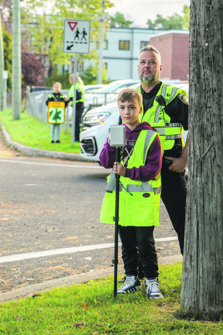 L’agent Dominic Brunet et Charles-Antoine Massé captent la vitesse des automobilistes au moment de leur entrée en zone scolaire. Photo François Larivière | L’Œil Régional