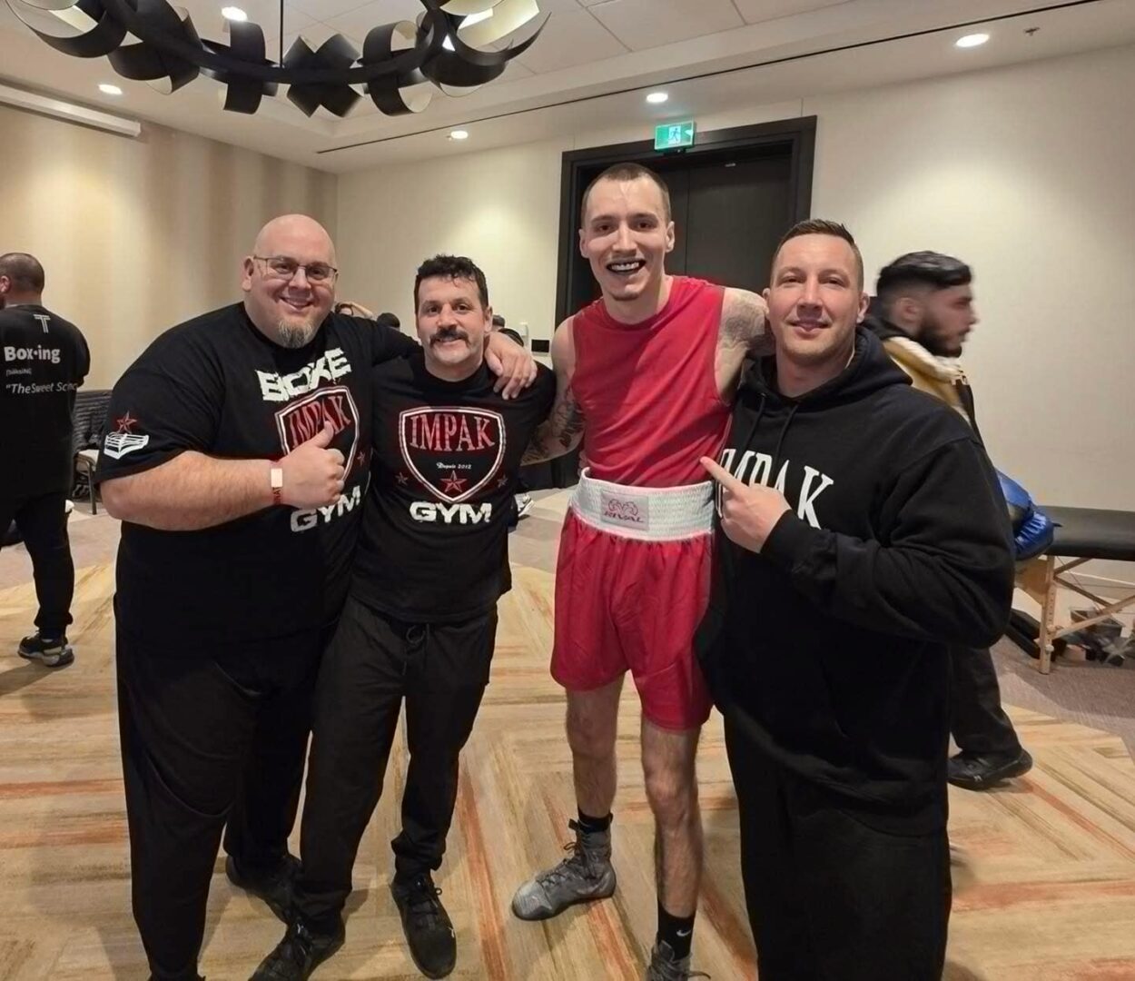 Le boxeur Marlon Proulx (deuxième à droite) en compagnie des entraîneurs Bob Landry, Jason Crevier et Francis Beaudet. Photo gracieuseté
