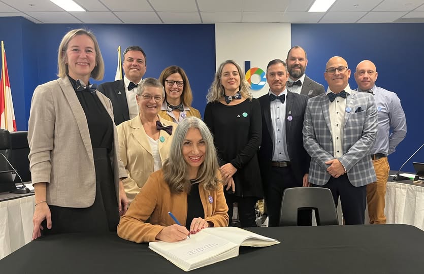 Martine Vallières signant le livre d’or de la municipalité en compagnie des membres du conseil municipal. Photo gracieuseté