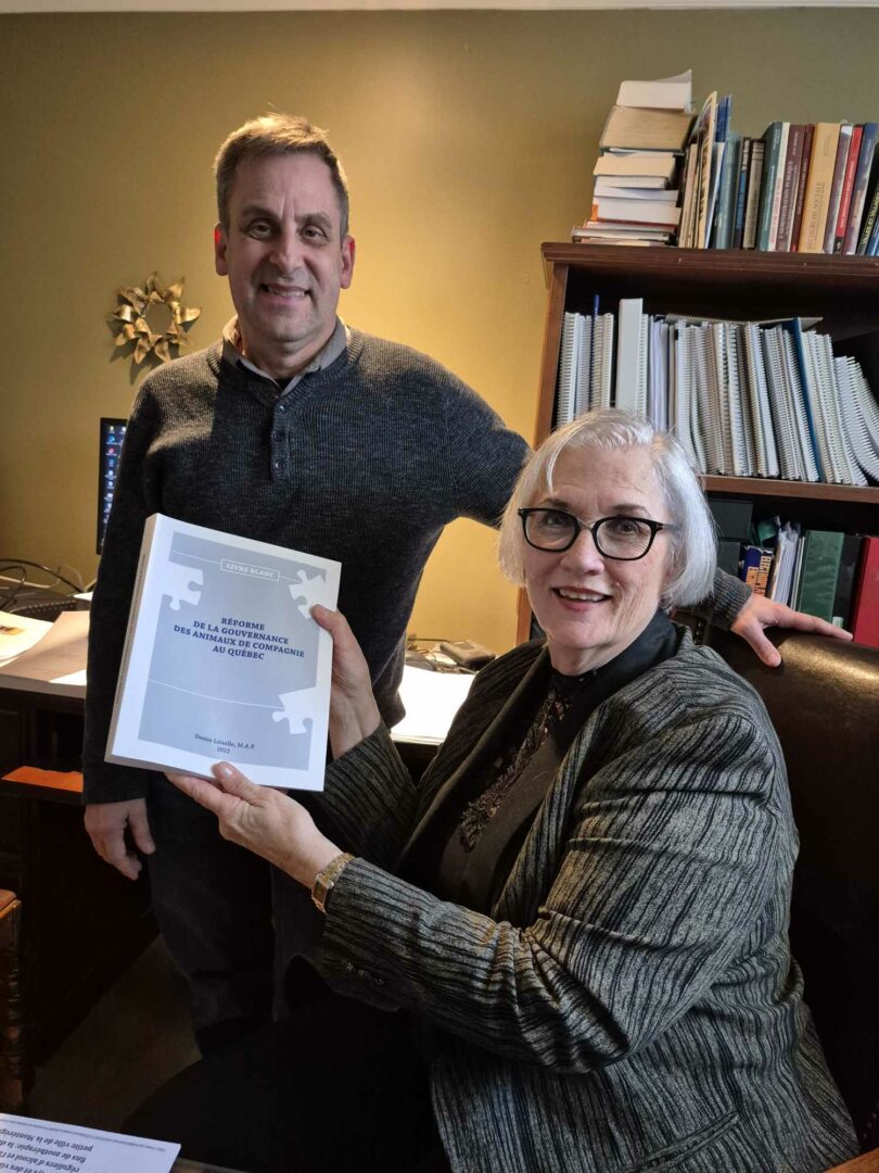 Patrick De Vos et Denise Loiselle posent avec une copie du livre blanc Réforme de la gouvernance des animaux de compagnie au Québec, un ouvrage qui a nécessité « des milliers d’heures de travail ». Photo Vincent Guilbault | L’Œil Régional ©