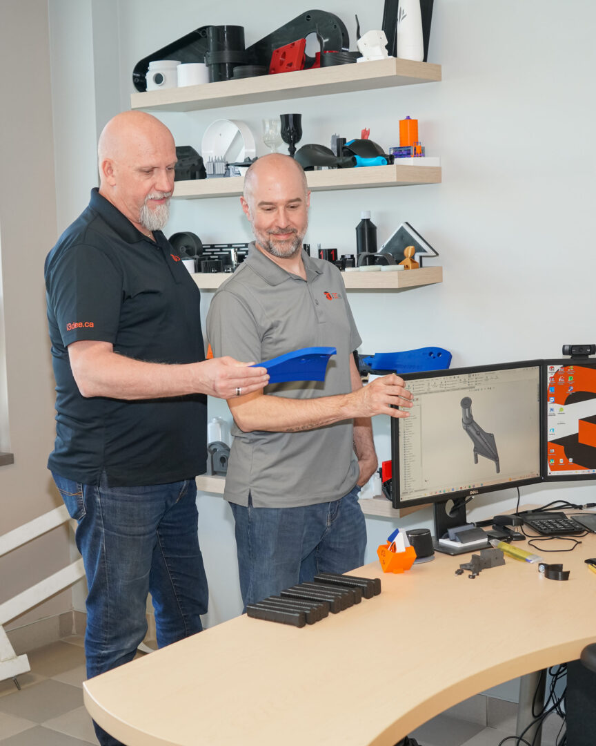 Éric Harvey et Gabriel Gosselin tenant une pièce fabriquée en impression 3D. Photo François Larivière | L’Œil Régional ©