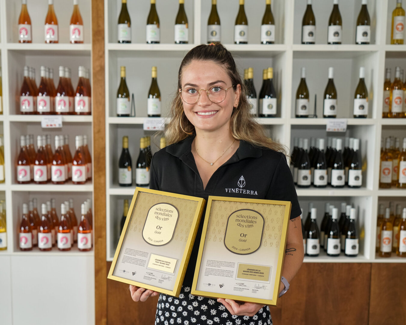 Eliane Martin affiche fièrement les prix des Sélections Mondiales des vins. Photo François Larivière | L’Œil Régional ©