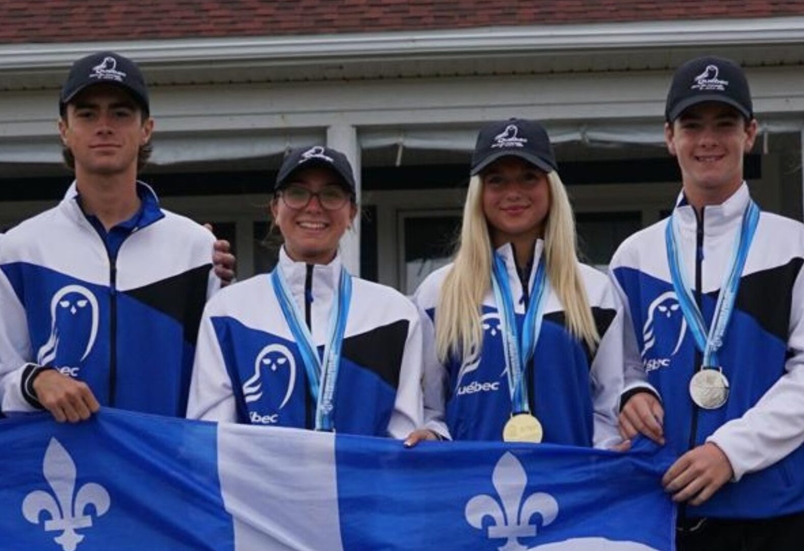 Mikaël Coupal, à gauche, et ses trois coéquipiers du Québec posant fièrement avec leur médaille et le drapeau de leur province. Photo gracieuseté