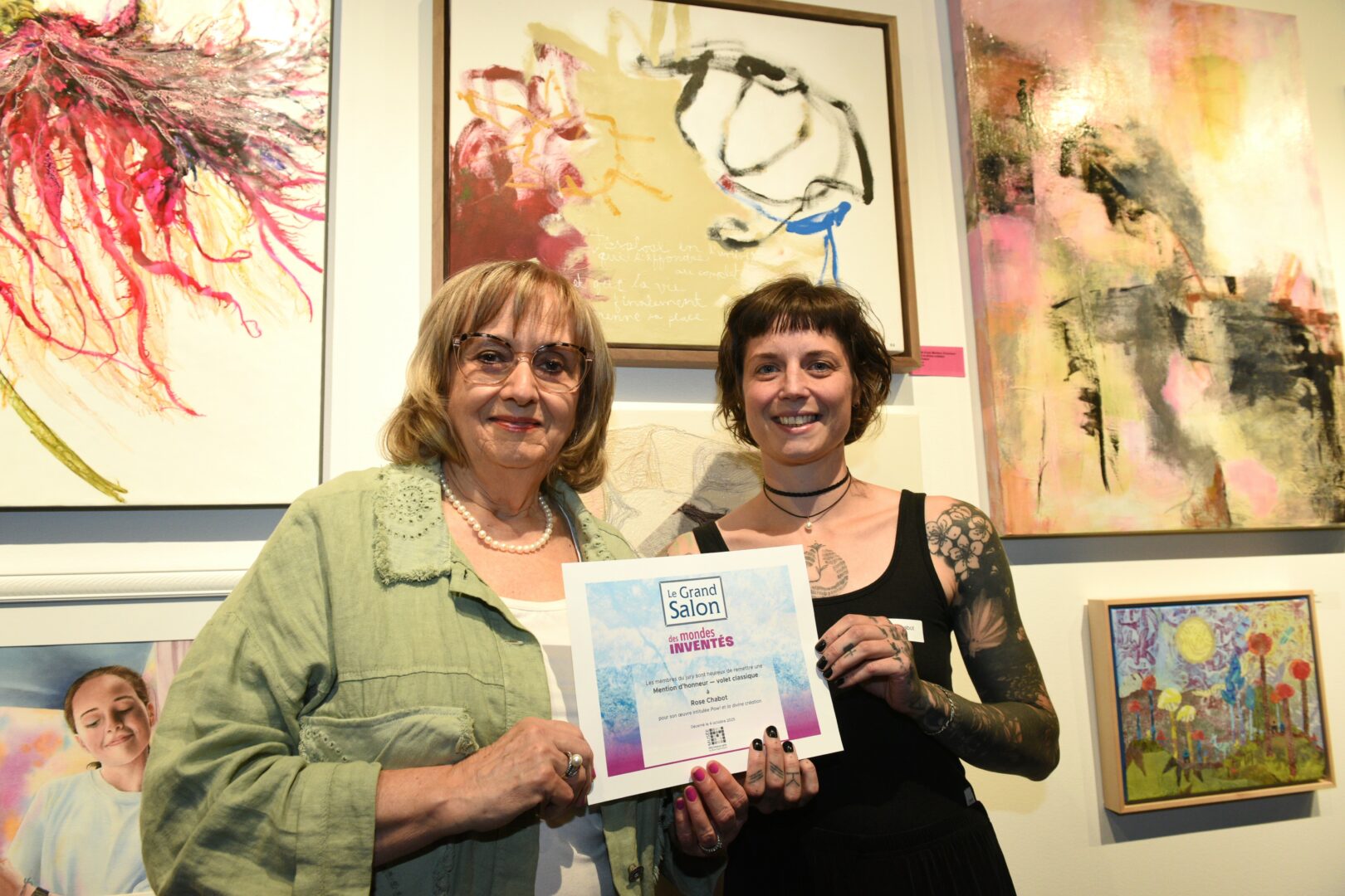 La Belœilloise Rose Chabot, à droite, a reçu une mention d’honneur des mains de la présidente du CA du MBAMSH, Francine Jacques, pour son œuvre « Pow! et la création divine ». Photo gracieuseté