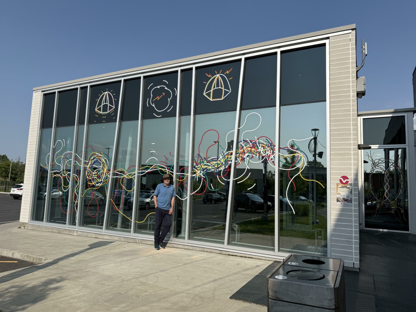 Jocelyn Fiset pose devant sa murale Nous n’allons pas assez loin, installée sur le Centre multifonctionnel de Carignan cet été. Photo gracieuseté